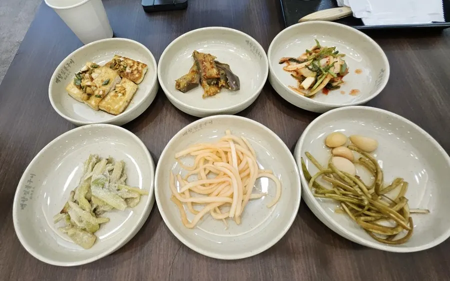 Ordered dishes cooking over straw fire