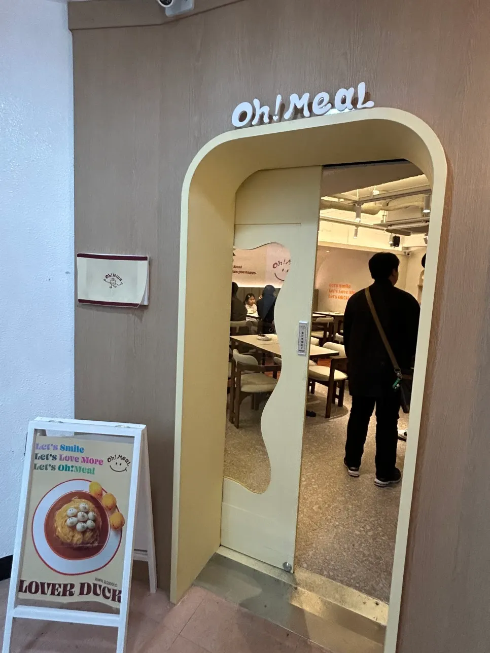Store entrance with cream-colored frame and wavy glass