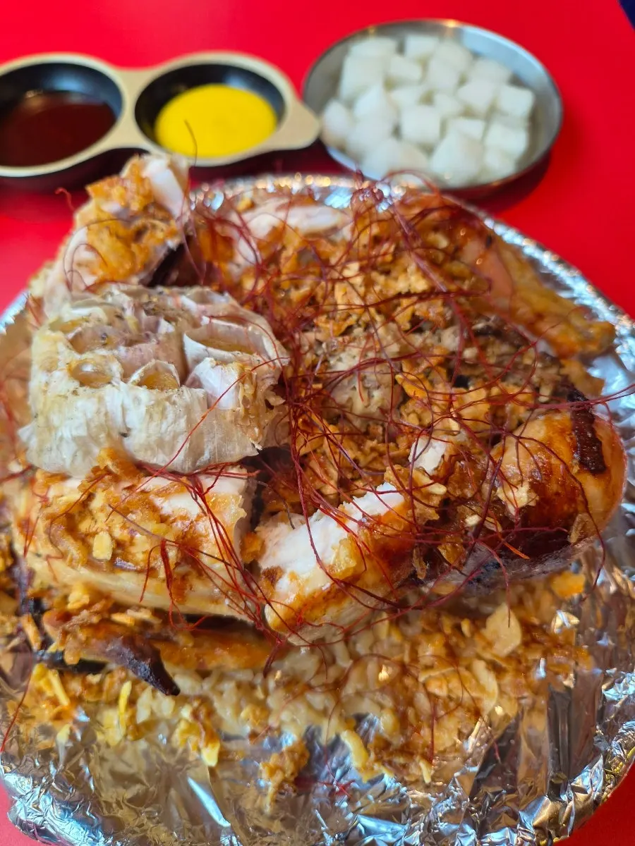 黄金ホイルに盛られた丸鶏と焼きニンニク