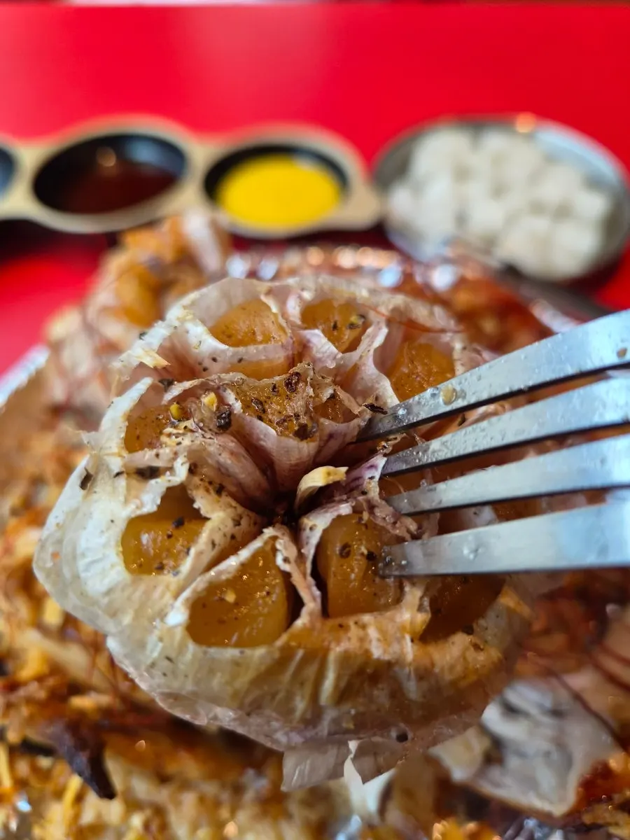 丸鶏の上にたっぷり乗った焼き六片ニンニク