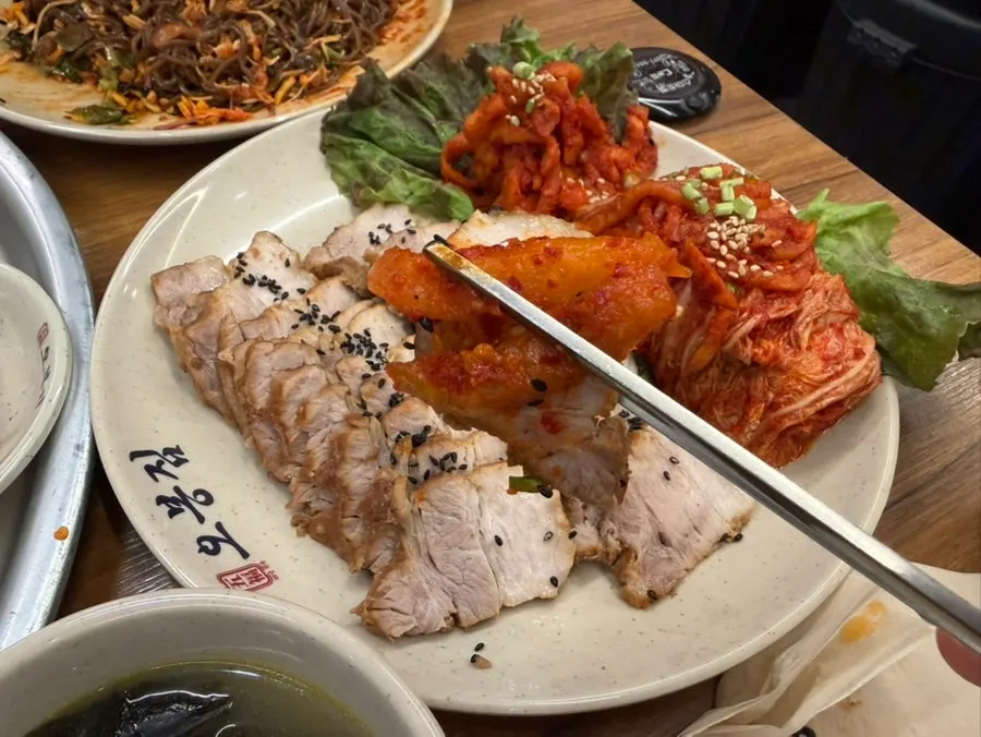 보쌈에 김치와 무생채를 올려 싼 한 쌈