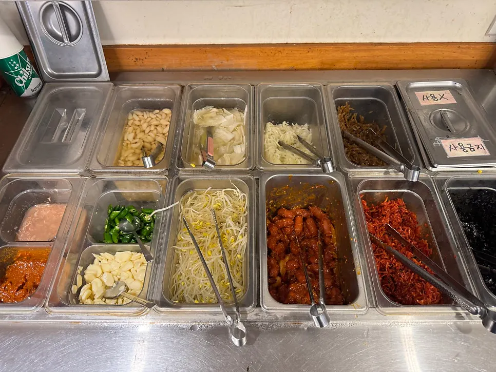 Plate of seasoned bean sprouts, stir-fried sausage, and other banchan