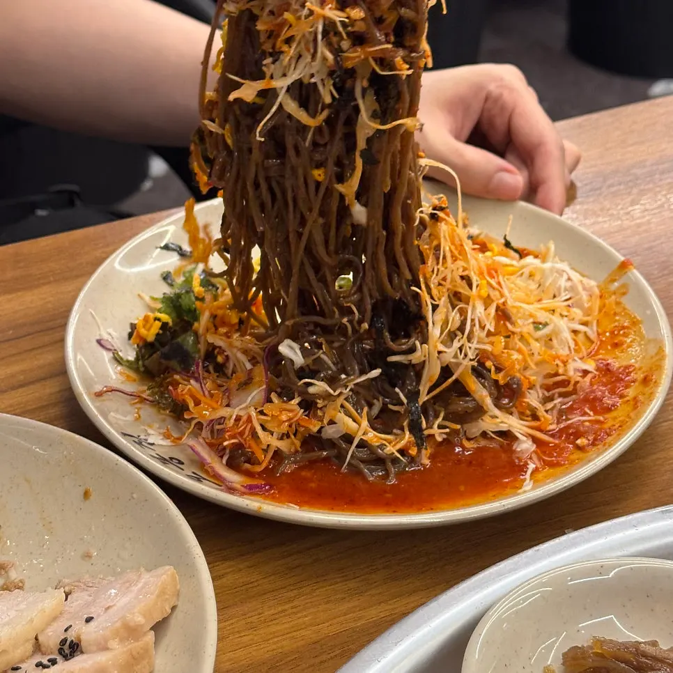 A piece of bossam topped with bossam kimchi