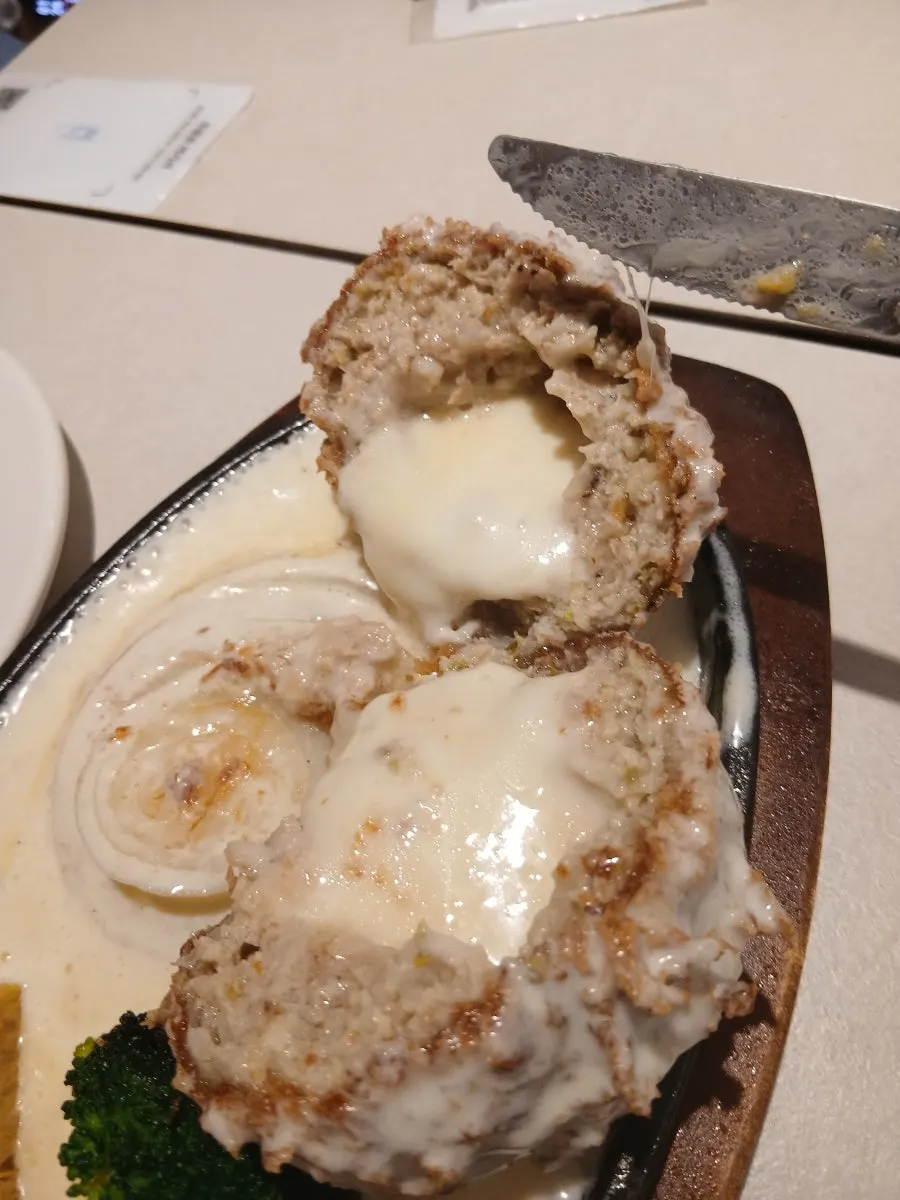 Mozzarella cheese stretching from the split cheese katsu