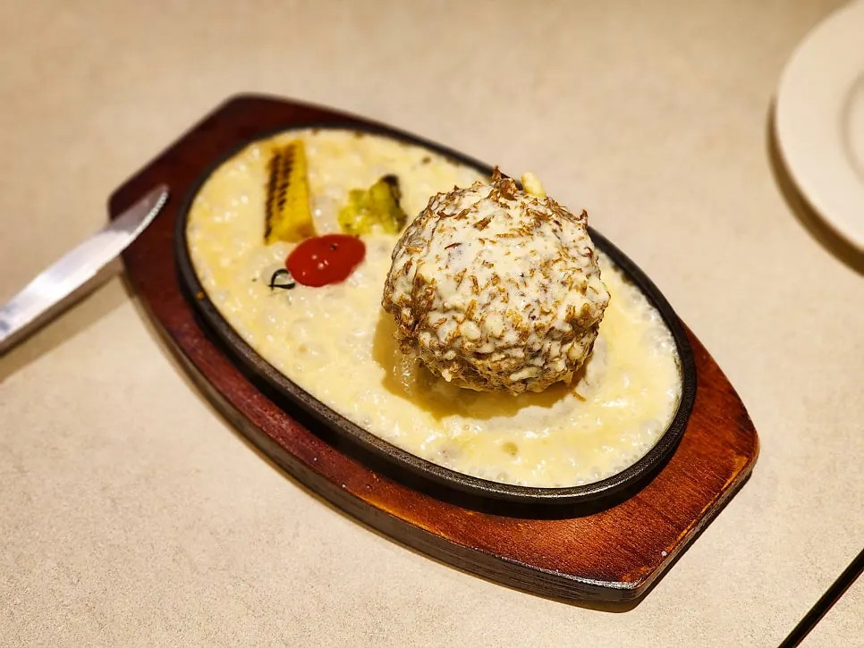 Pork cutlet topped with bubbling cheese sauce