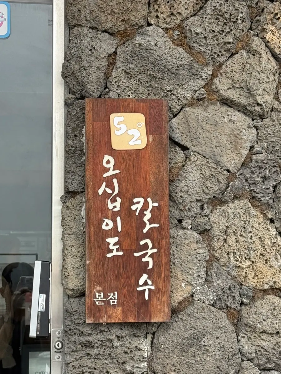 검은 돌로 꾸며진 오십이도칼국수 건물 외벽