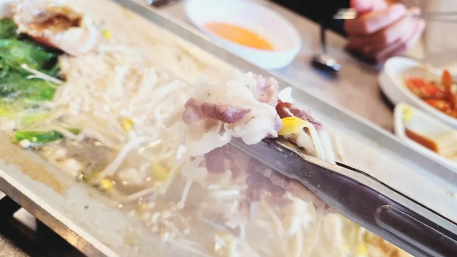 A bite of beef brisket with bean sprouts