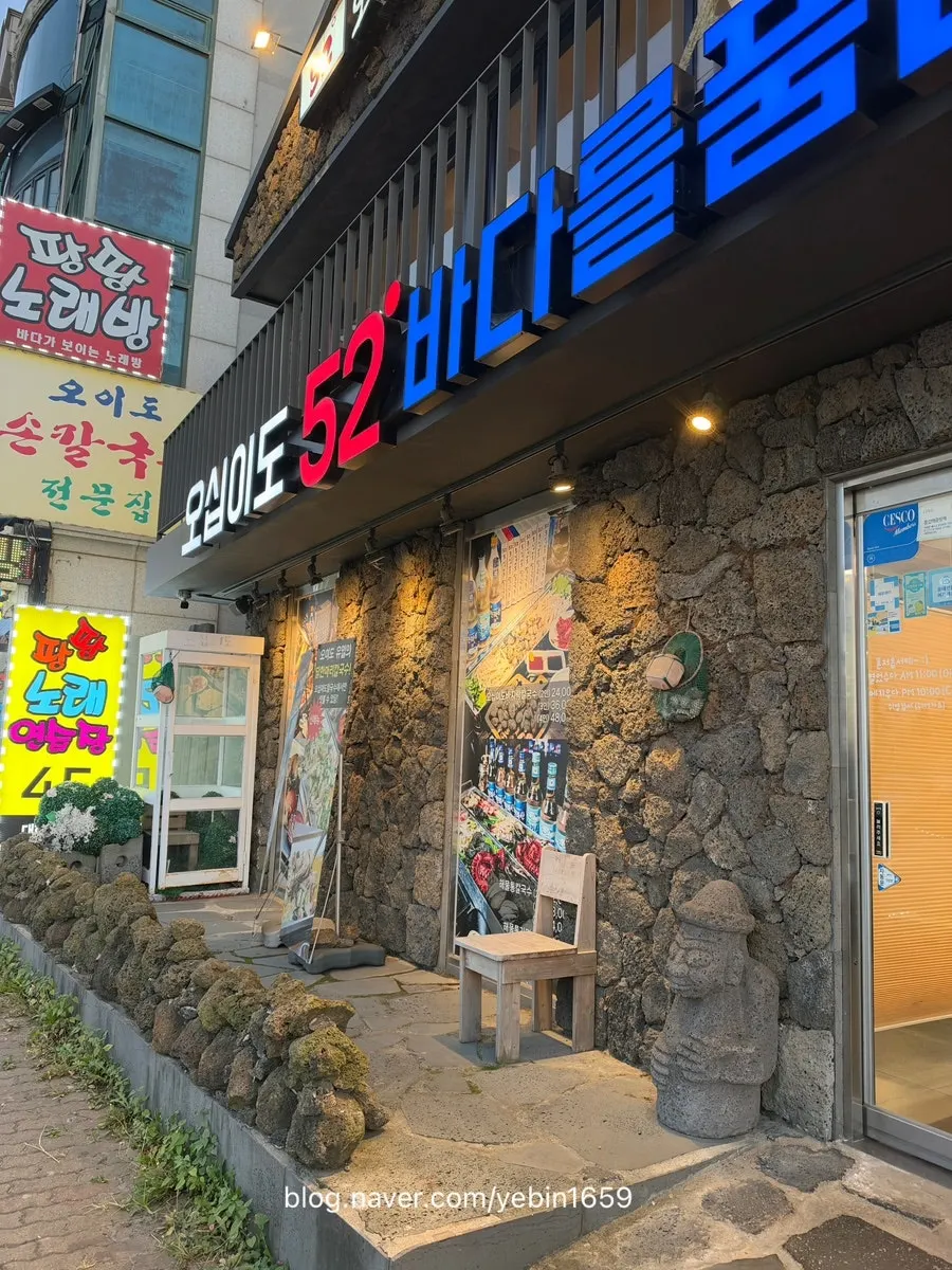 Storefront decorated with a stone wall and dolhareubang statues