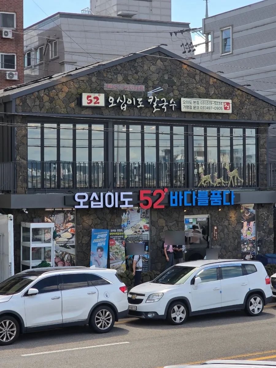 Entrance with a dolhareubang and black-basalt stone wall