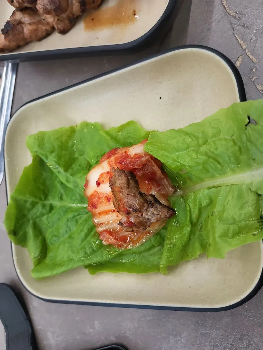 젓가락으로 집어 든 구운 생고기 한 점