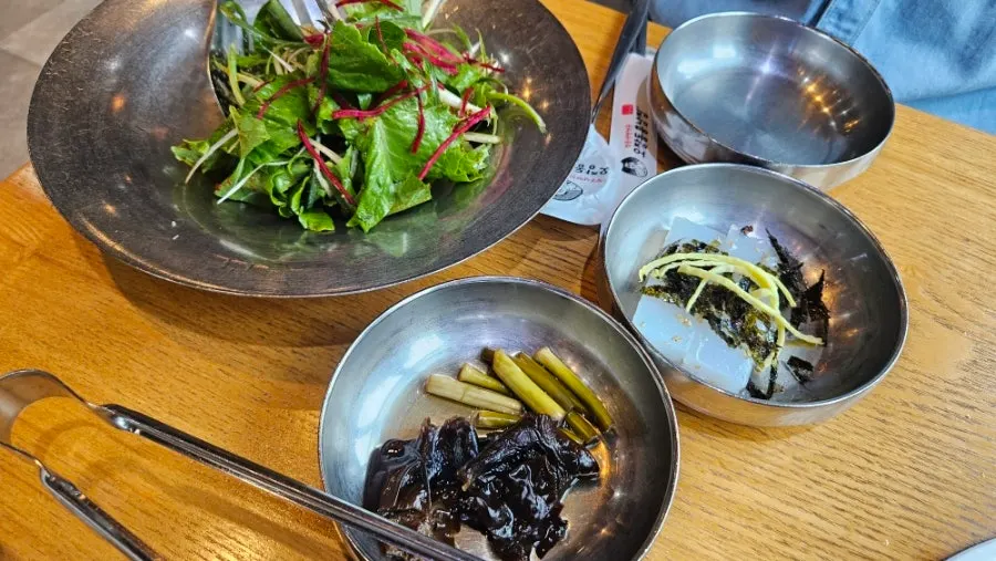 A full table setting with raw hanwoo bulgogi and rice