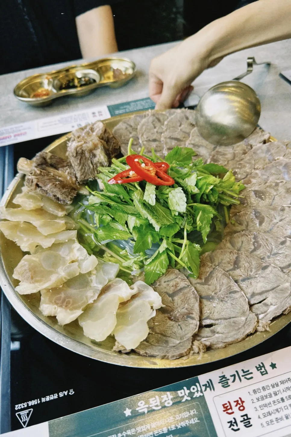 Fishing out pork from the assorted boiled pork hot pot