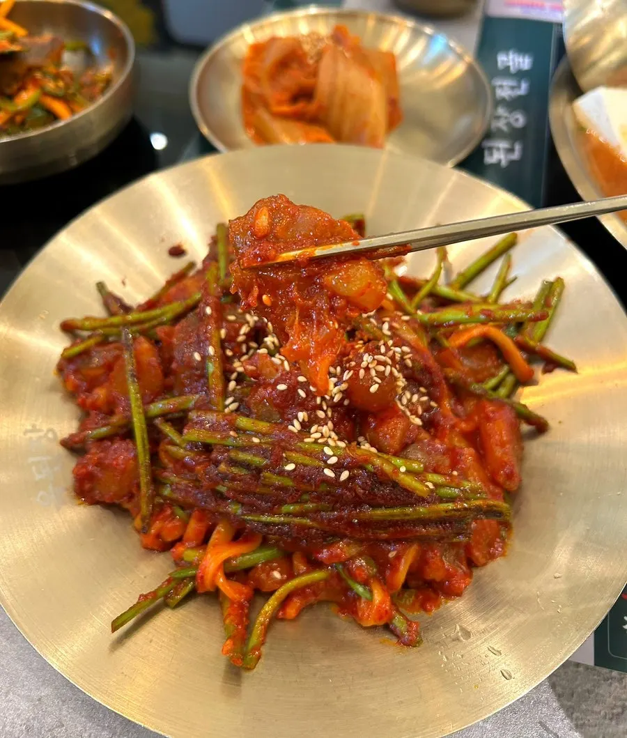 Kalguksu noodles lifted up, coated in sauce