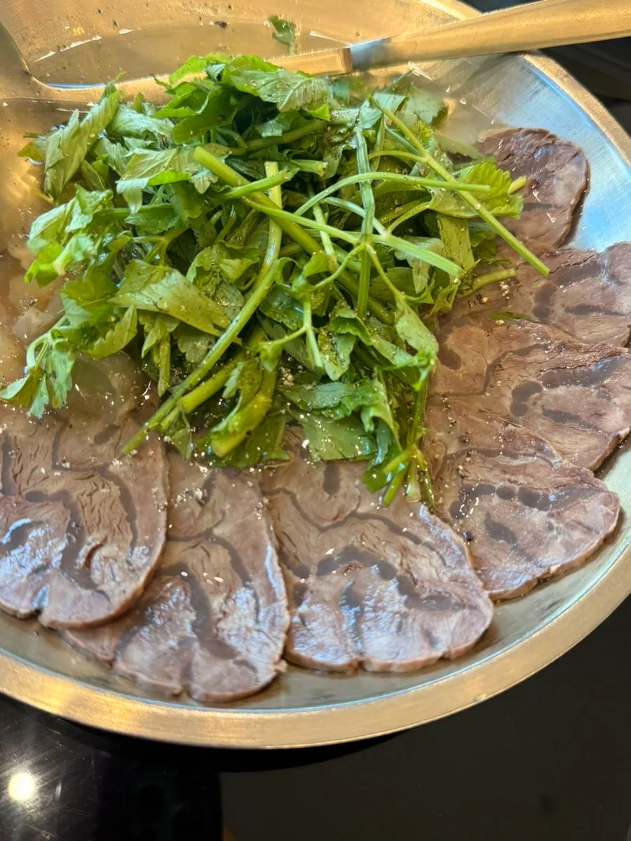 Small assorted boiled pork hot pot bubbling on the stove