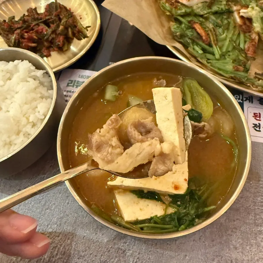 Doenjang hot pot bubbling with the sand timer beside it