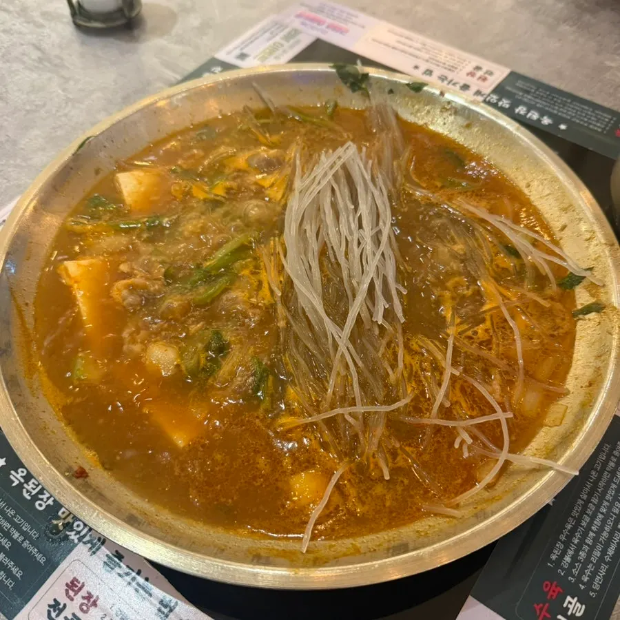 A ladle scooping out savory doenjang hot pot broth