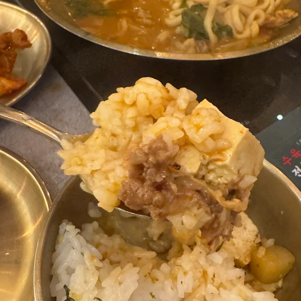 Ladle scooping tofu and beef from the doenjang hot pot