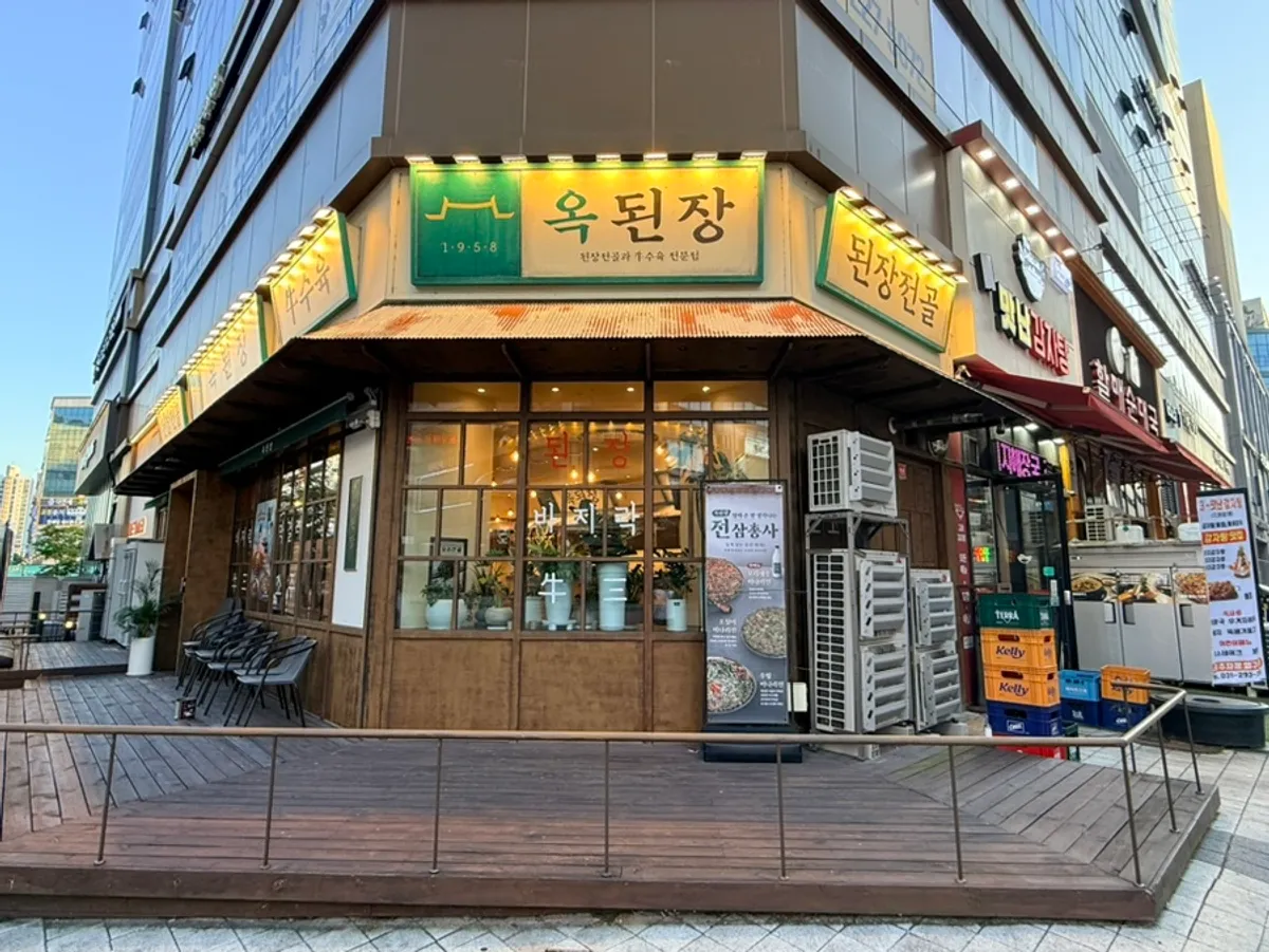 건물 코너에 자리한 옥된장 수원호매실점 외관