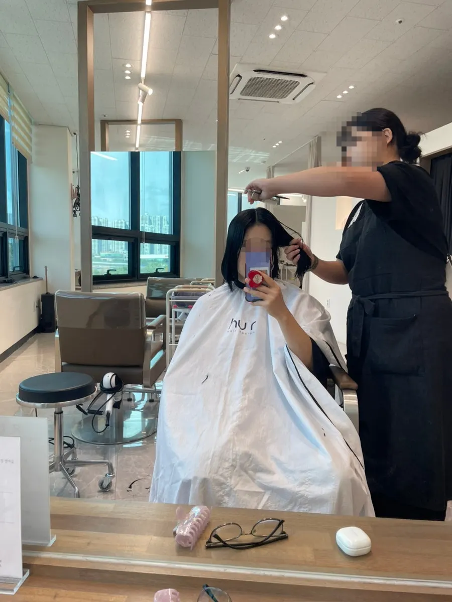 Checking hair condition during layered cut consultation