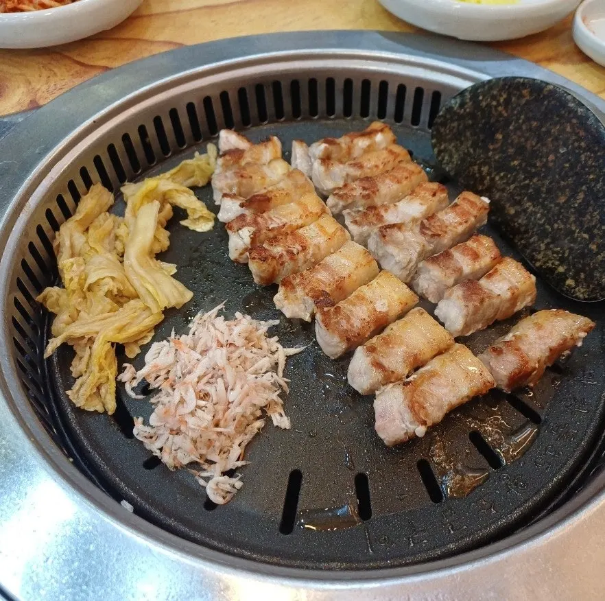 Pork belly topped with side dishes like sushi