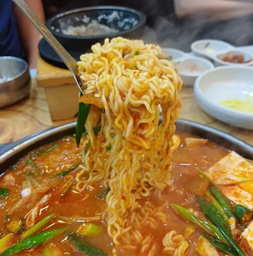 Boiling aged kimchi stew broth with ramen noodles