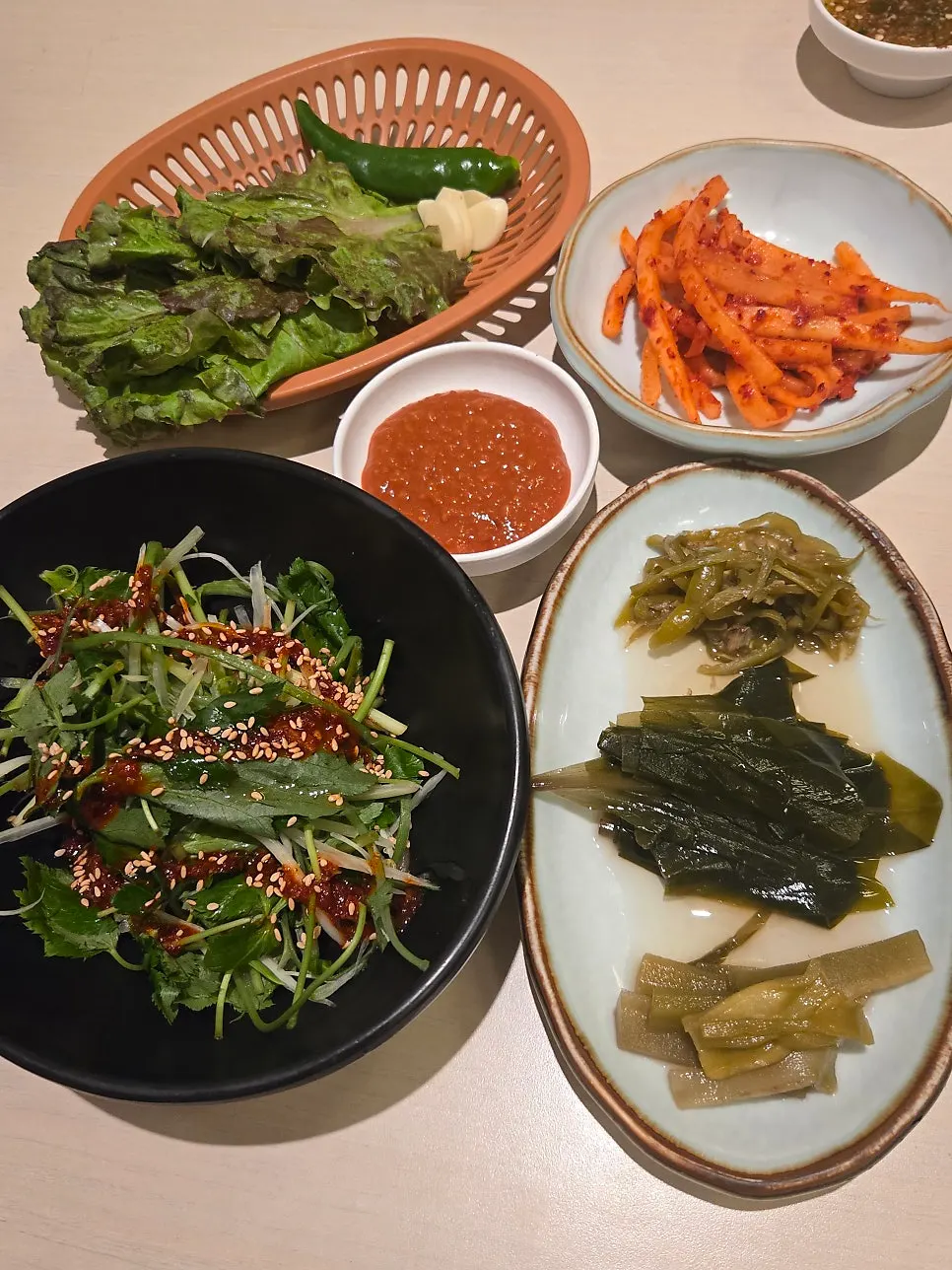 Side dishes: shredded scallions, lettuce wraps, radish salad, and myeongi-namul
