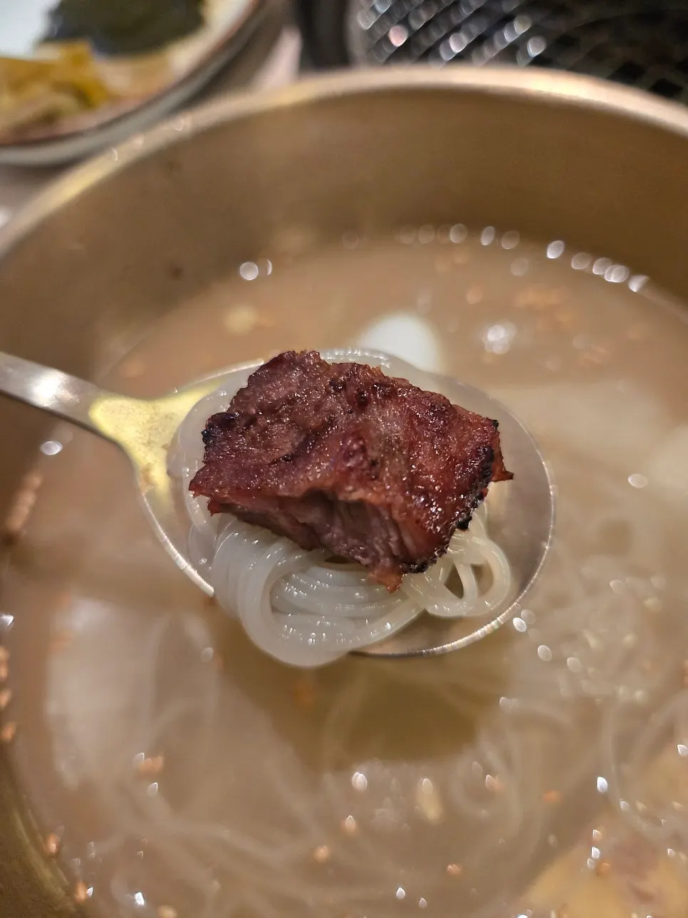 Bbolsal placed on top of mul-naengmyeon noodles