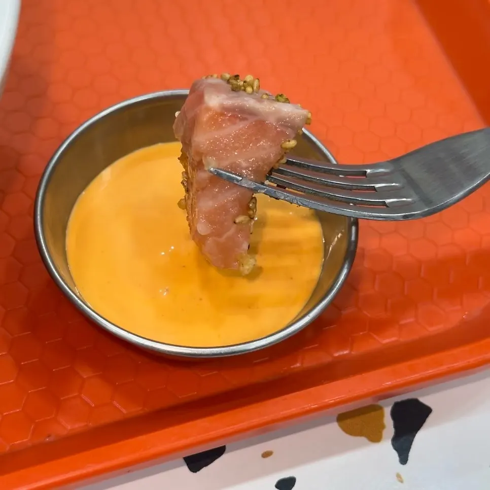 Raw salmon dipped in sriracha mayo sauce