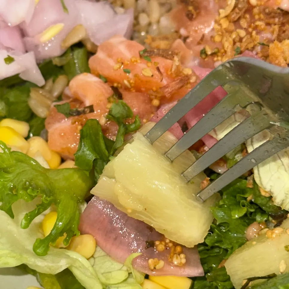 A spoonful of salmon poke lifted up
