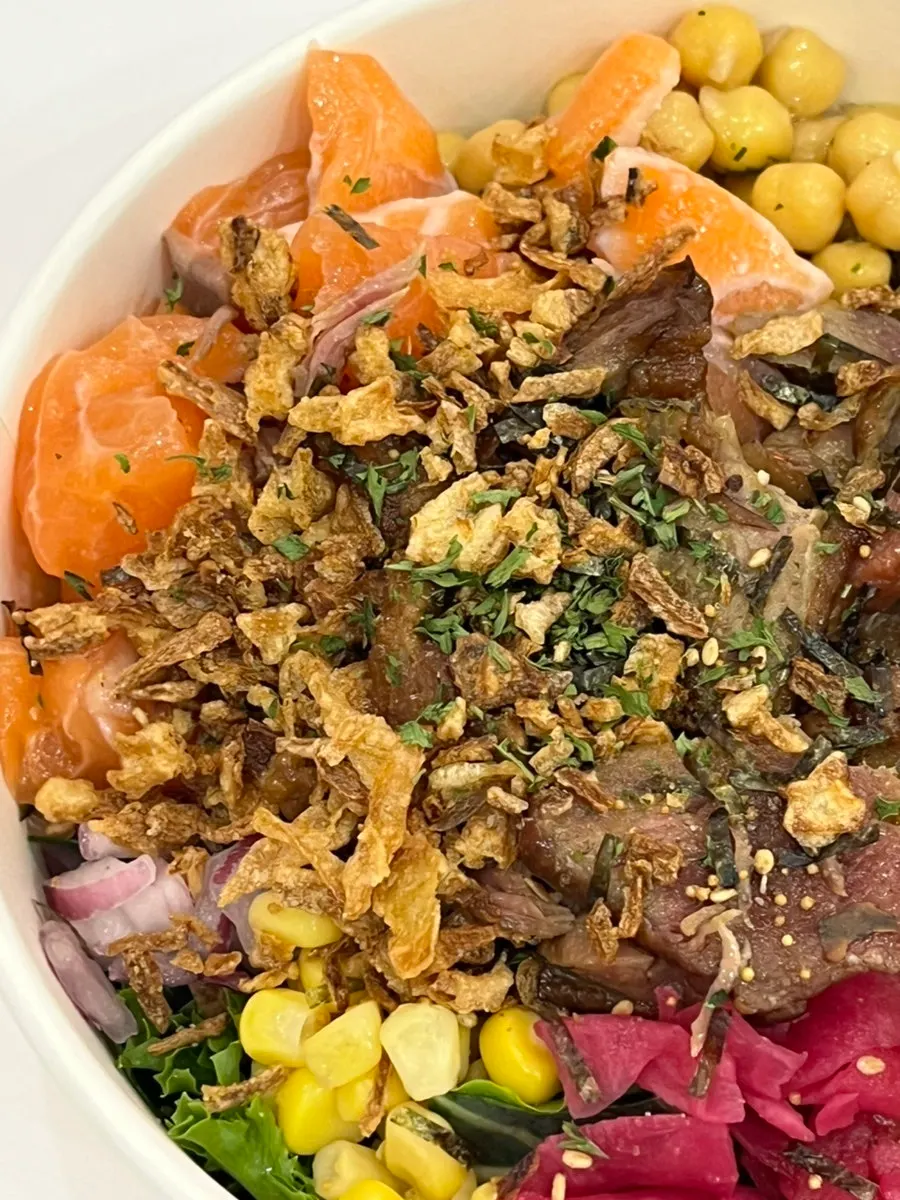 A salmon poke bowl piled high with vegetables
