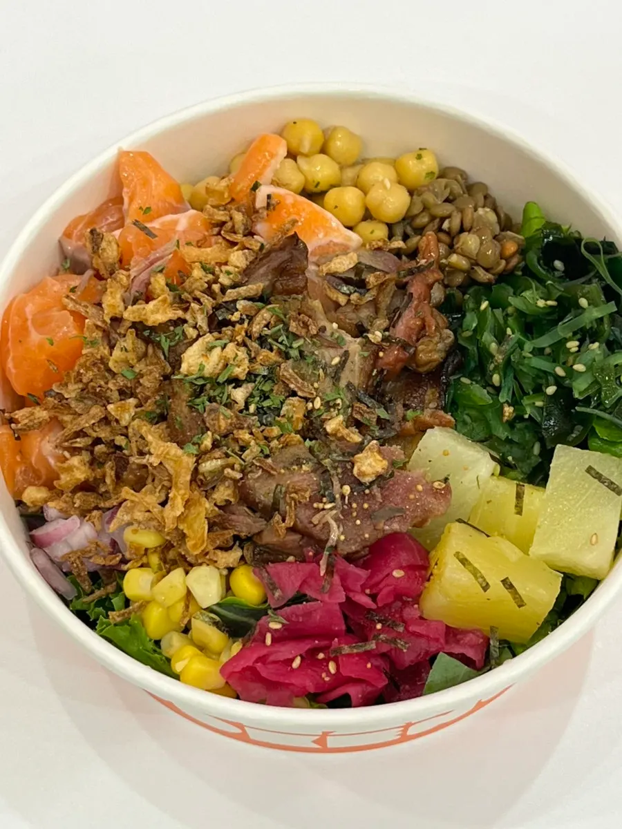 Crunchy vegetables mixed with protein toppings in a poke bowl
