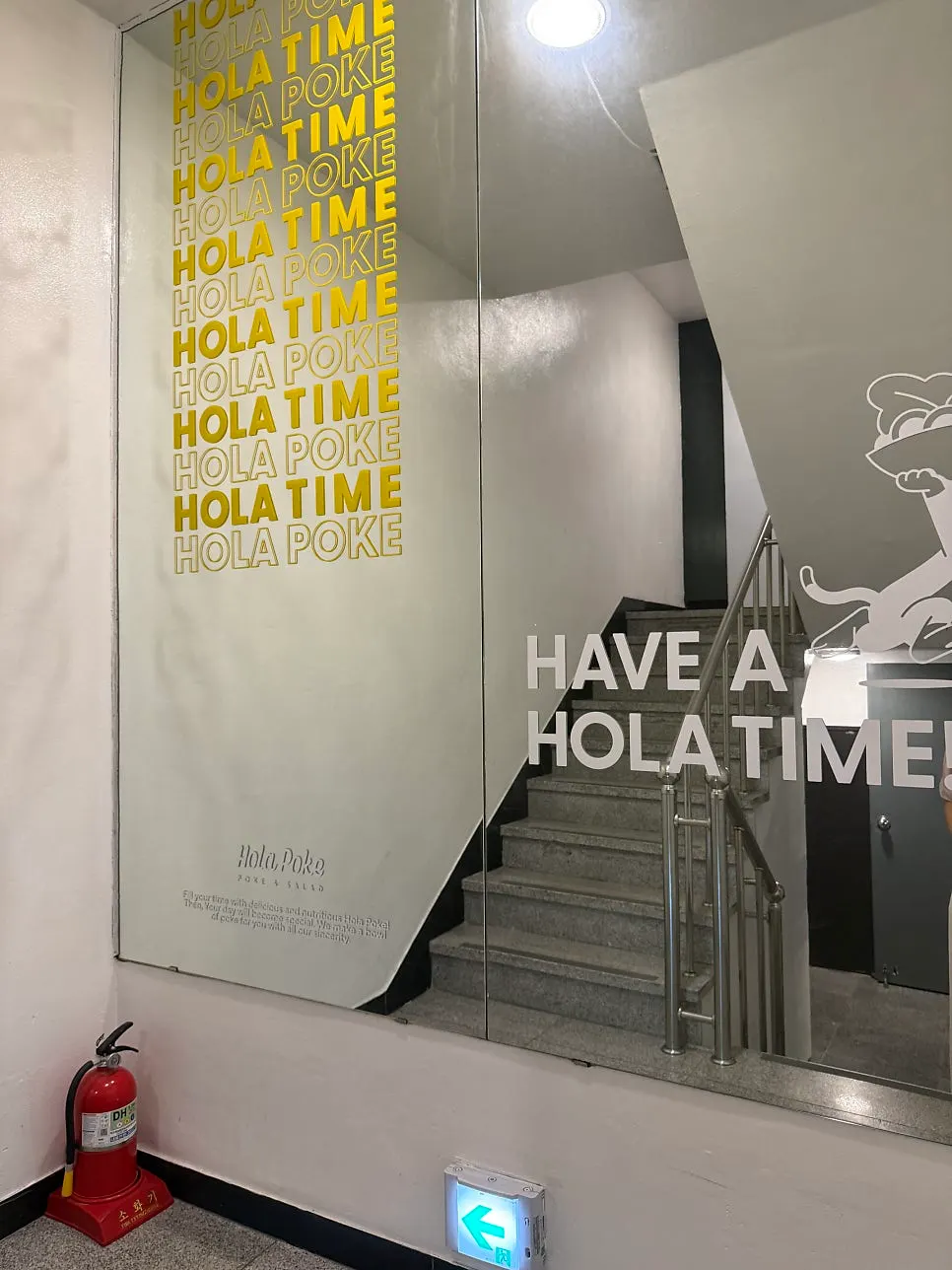 Right entrance with a 'poke by day, pizza by night' banner