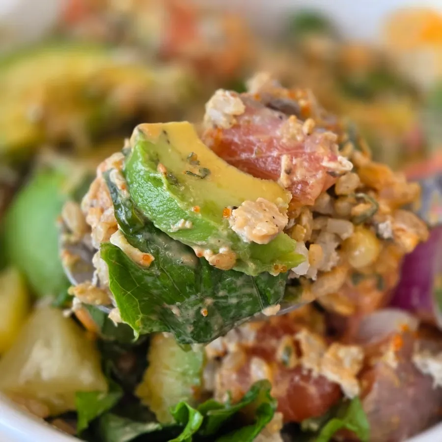 A spoonful of poke lifted from the bowl