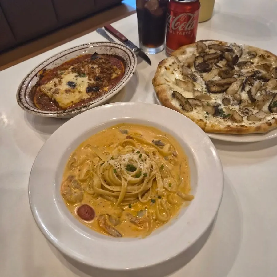 Table set with pizza, pasta, and lasagna