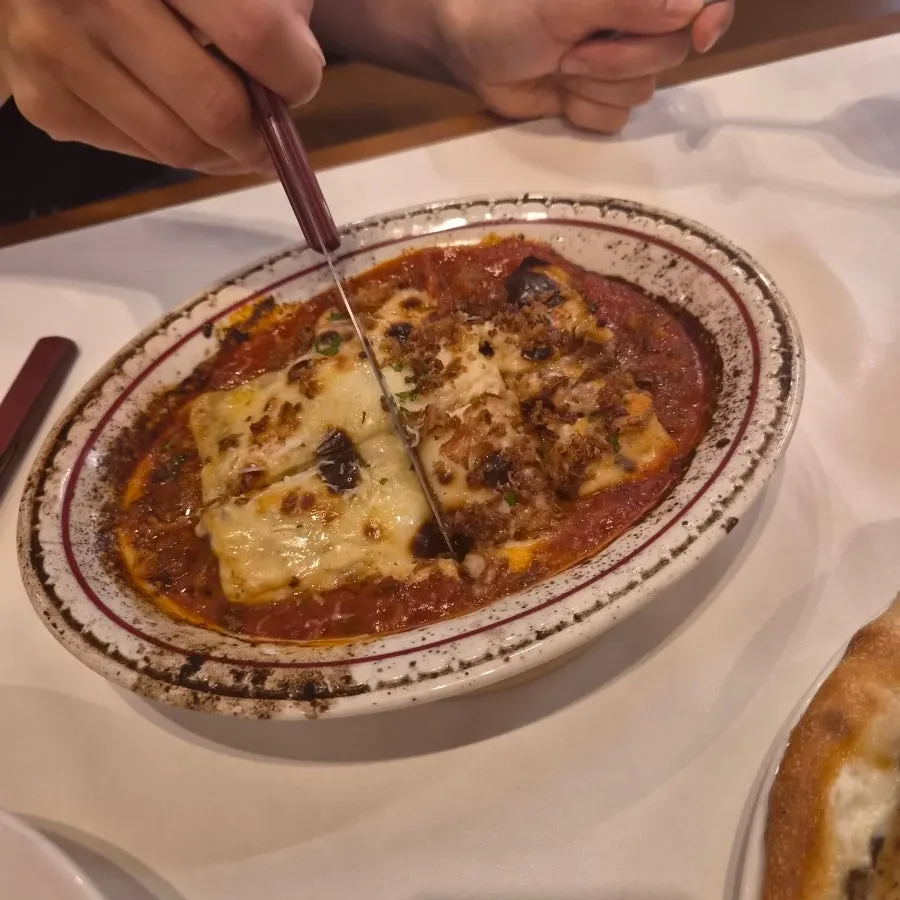 A plate of homemade lasagna showing the ragu sauce