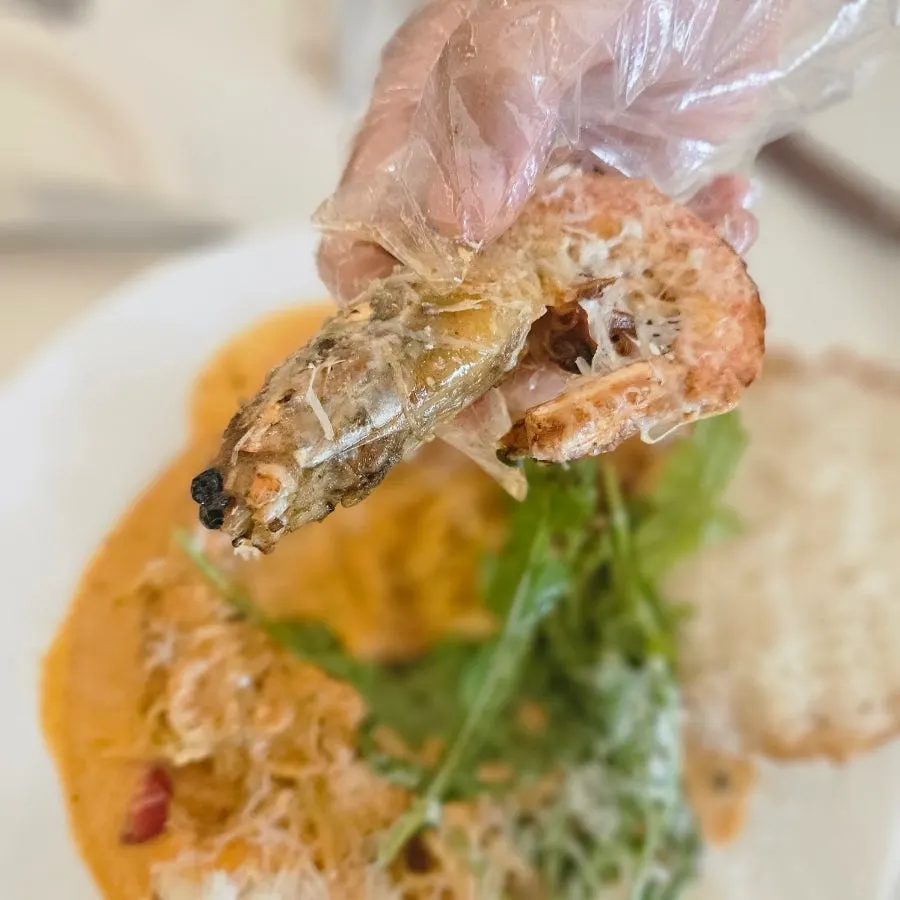 Peeling sweet shrimp shells with gloves and scissors