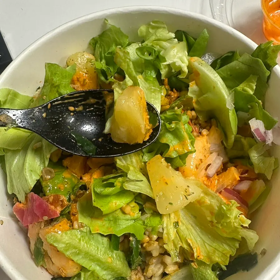 Pouring sauce over the poke bowl