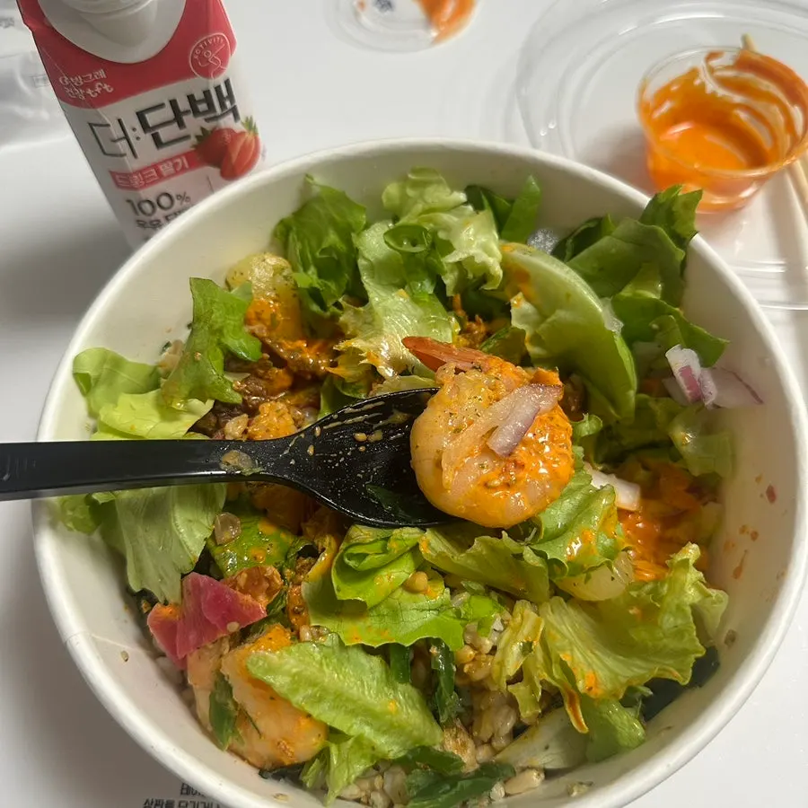 A spoonful of brown rice, vegetables and shrimp mixed together