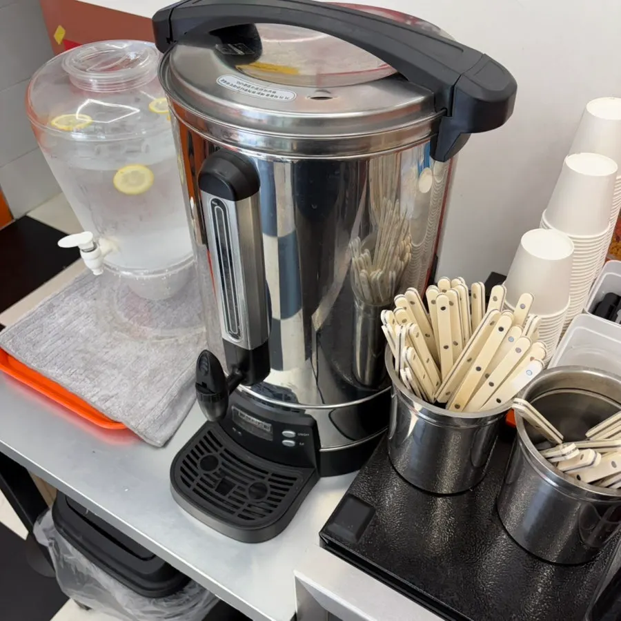 Self-service corner with forks, spoons, and water