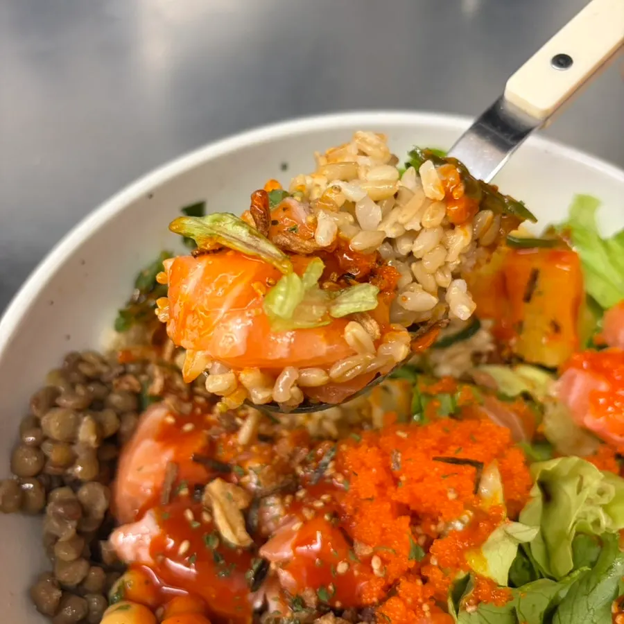 Close-up of salmon and salad topped with buldak sauce