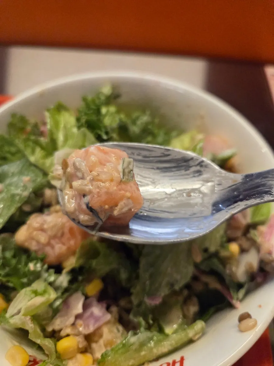 A bite of poke with rice and vegetables together