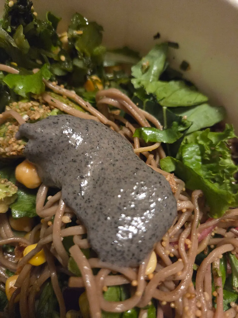 A scoop combining buckwheat noodles, vegetables, and avocado