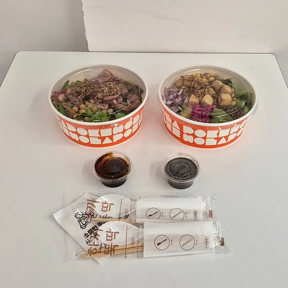 Two poke bowls packed for takeout