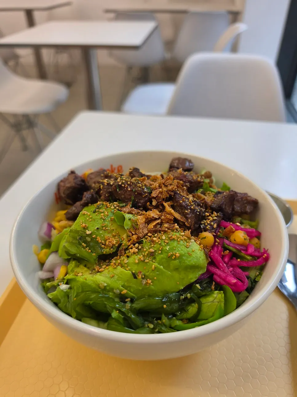 A bowl of steak poke topped with wasabi mayo sauce