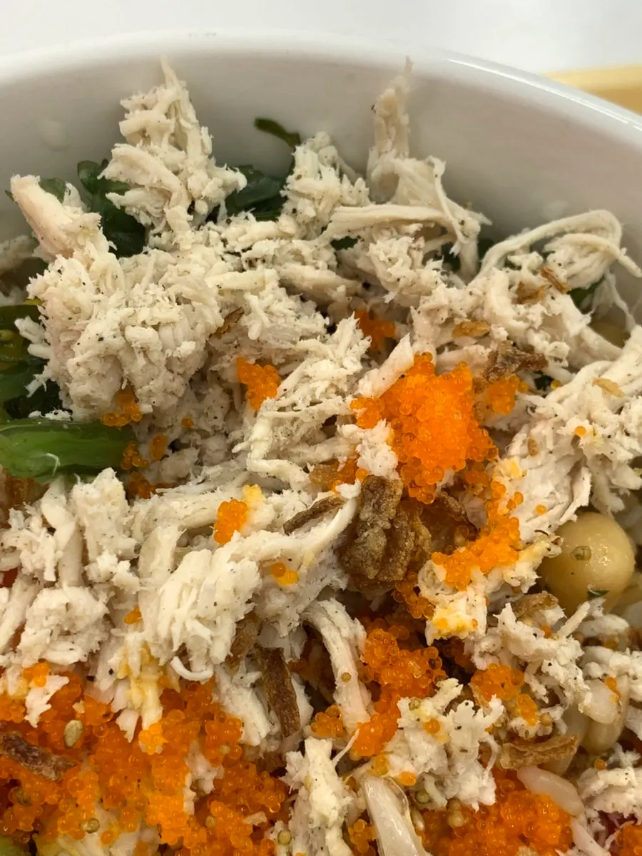 A bite of poke with protein toppings and vegetables