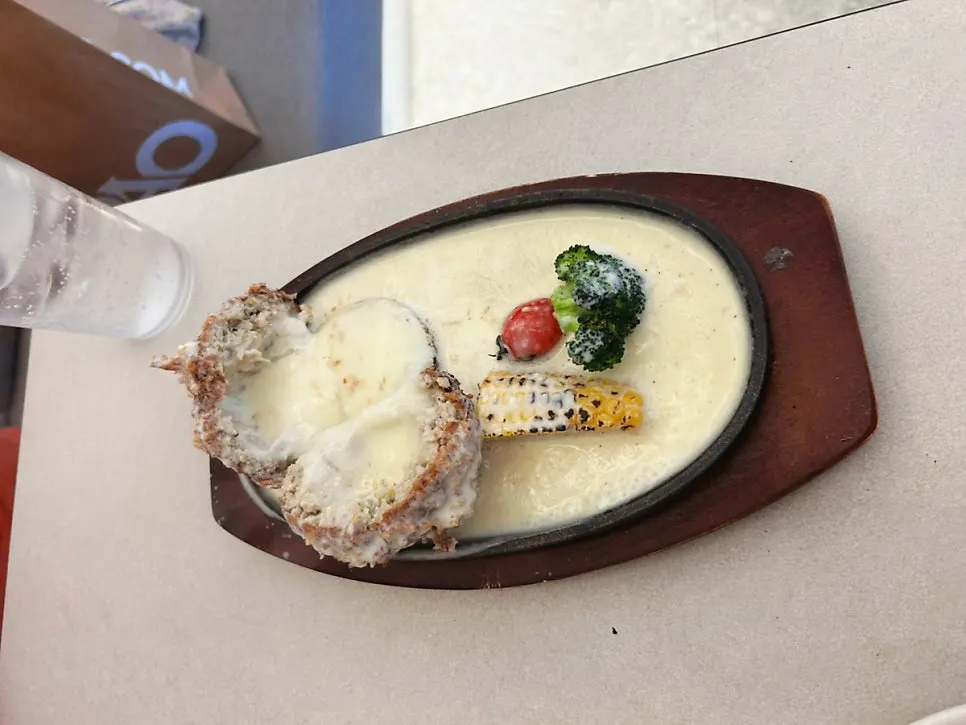 Close-up of the cutlet topped with cheese on the hot plate