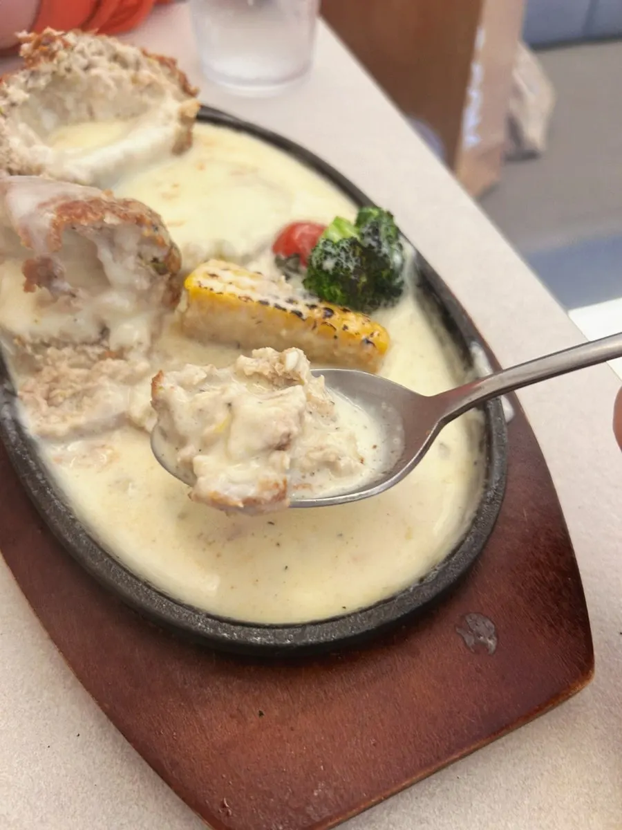 A piece of the sizzling cheese cutlet with the cheese stretching
