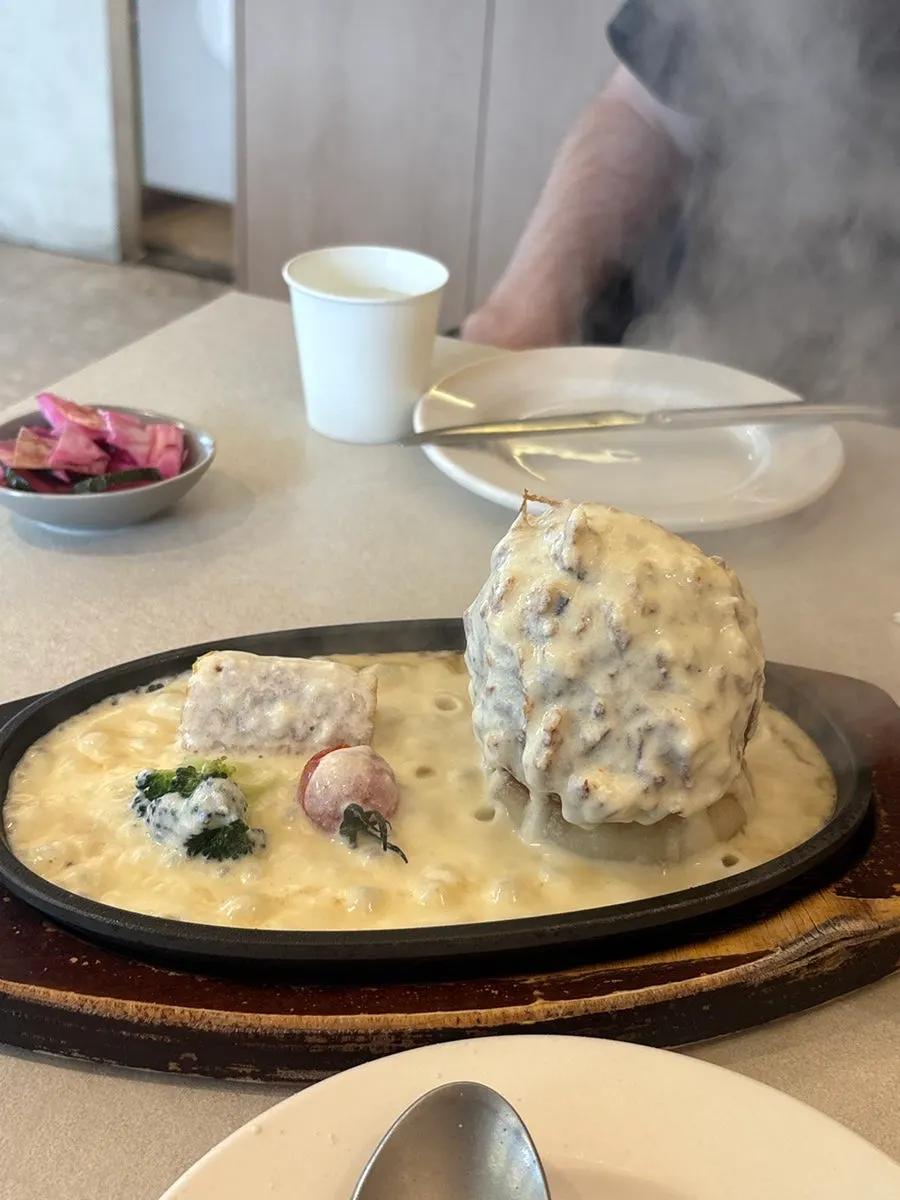 Cheese melting over the pork cutlet on the iron plate