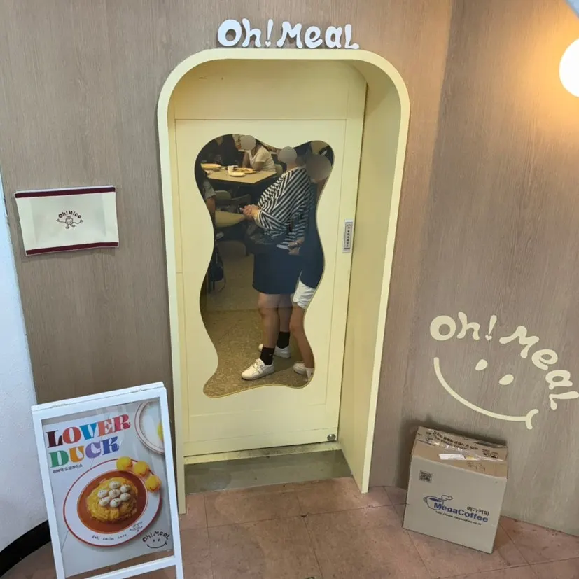 Butter-colored entrance door and the Omil logo