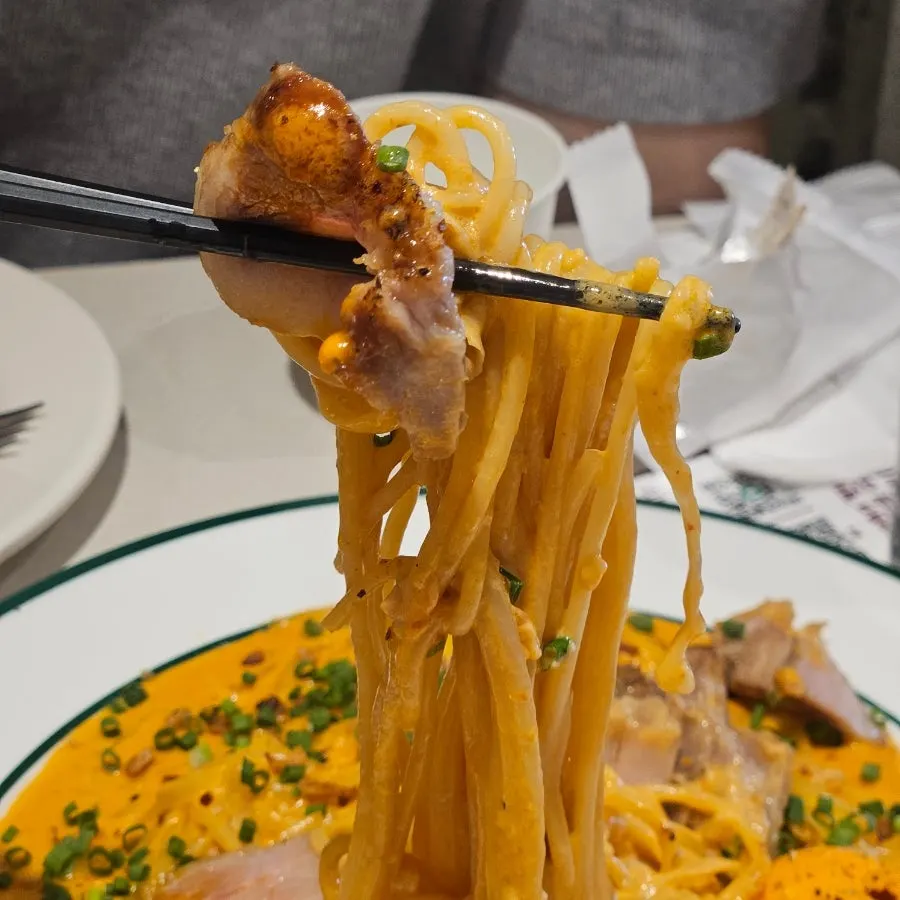 Close-up bite of gochujang butter pasta with sauce coating the noodles